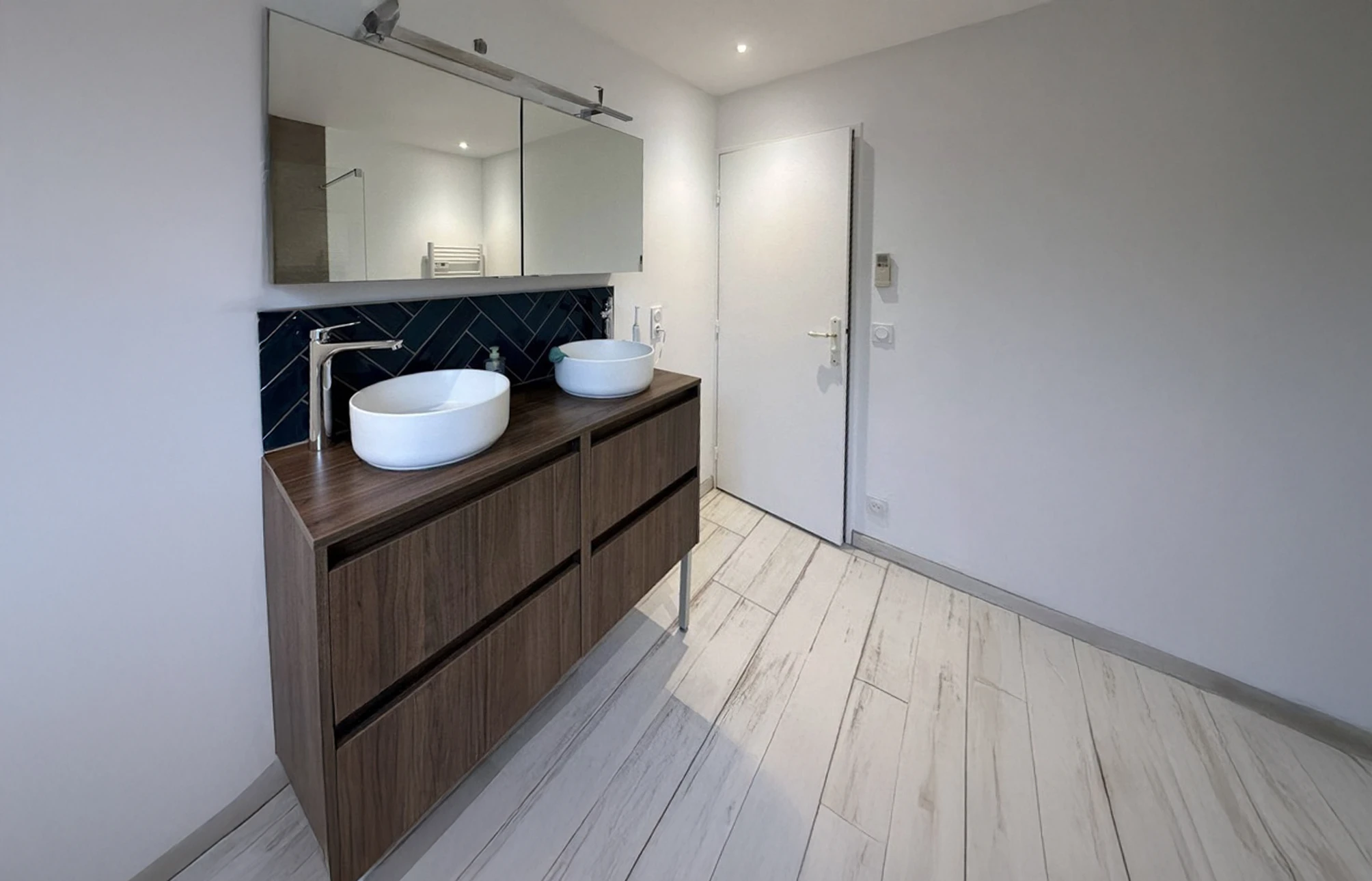 Salle de bain moderne avec double vasque à poser blanche sur meuble suspendu en bois foncé à tiroirs