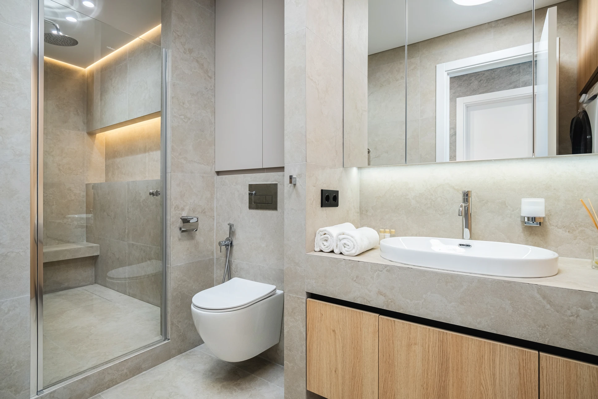 Salle de bain moderne avec douche à l'italienne, vasque rectangulaire blanche sur plan de travail bois, WC suspendu blanc