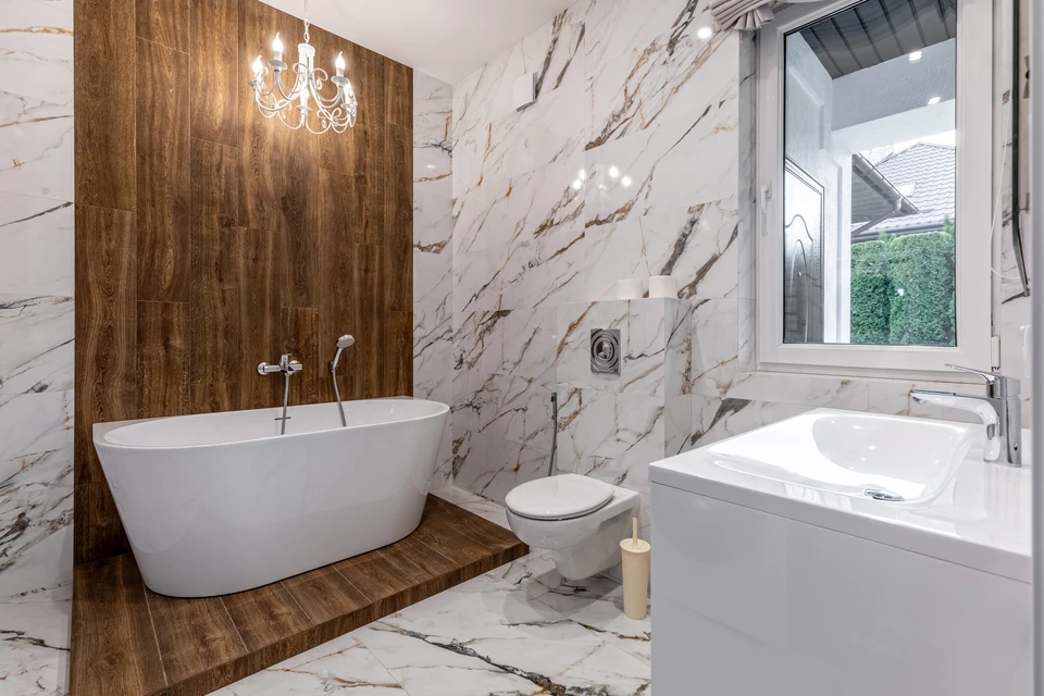 Artisan carreleur installant du carrelage gris au sol, utilisant un niveau à bulle pour vérifier l'alignement