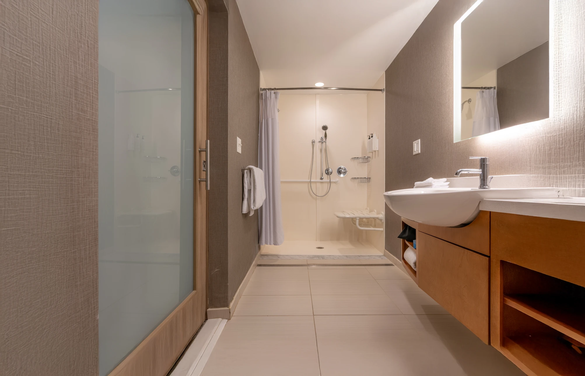 Sanitaires collectifs modernes avec rangée de lavabos intégrés en solid surface blanc