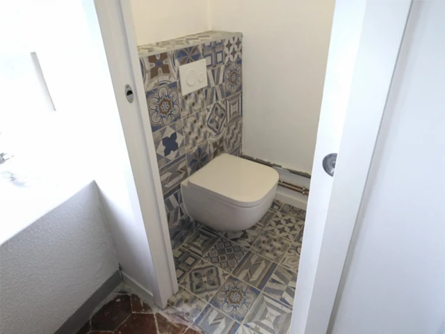 Salle de bain moderne avec douche à l'italienne, double vasque sur meuble suspendu en bois clair, miroir large et éclairage LED