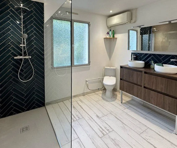 Salle de bain moderne haut de gamme avec douche à l'italienne vitrée, meuble vasque suspendu en bois texturé, miroir rétroéclairé LED